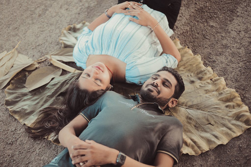 A Couple Lying Close on a Giant Dried Leaf in Opposite Directions