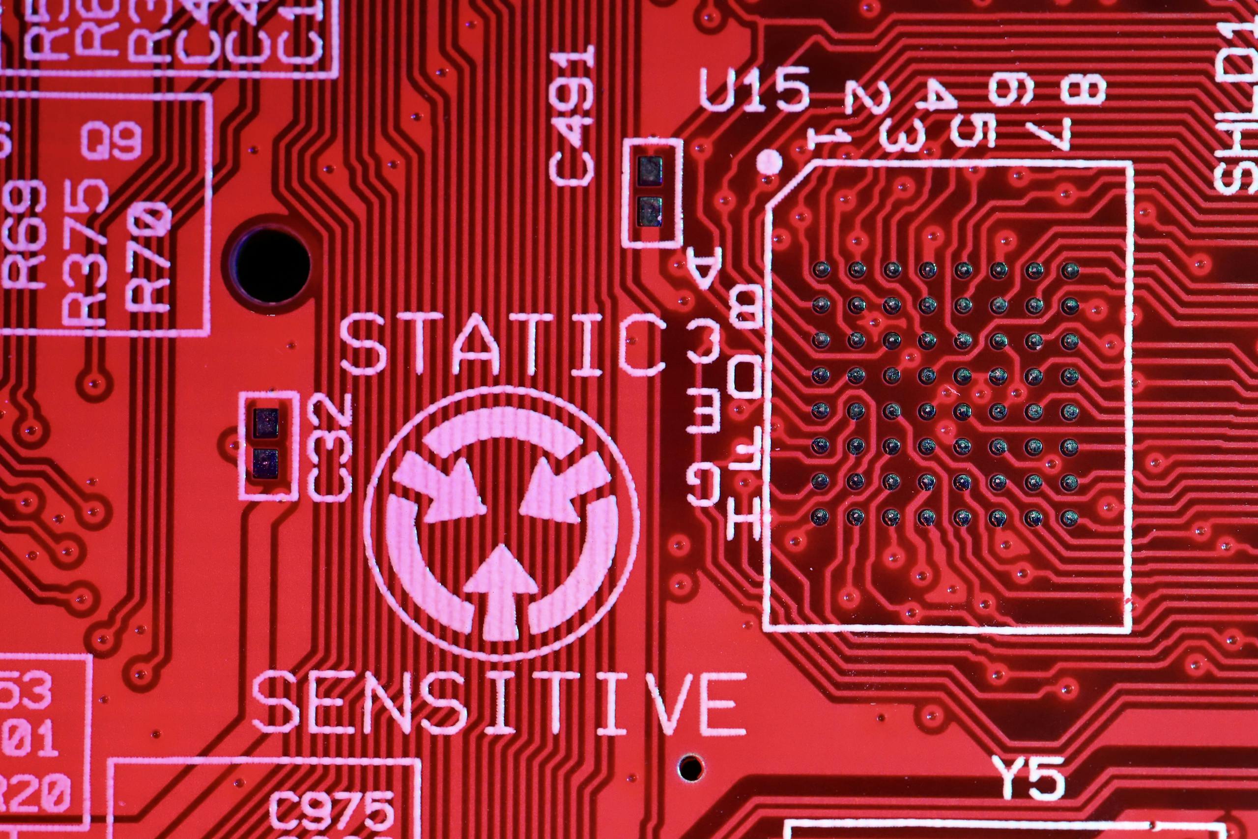Background of modern colorful printed board of digital device with electric circuits and written words with numbers on red surface