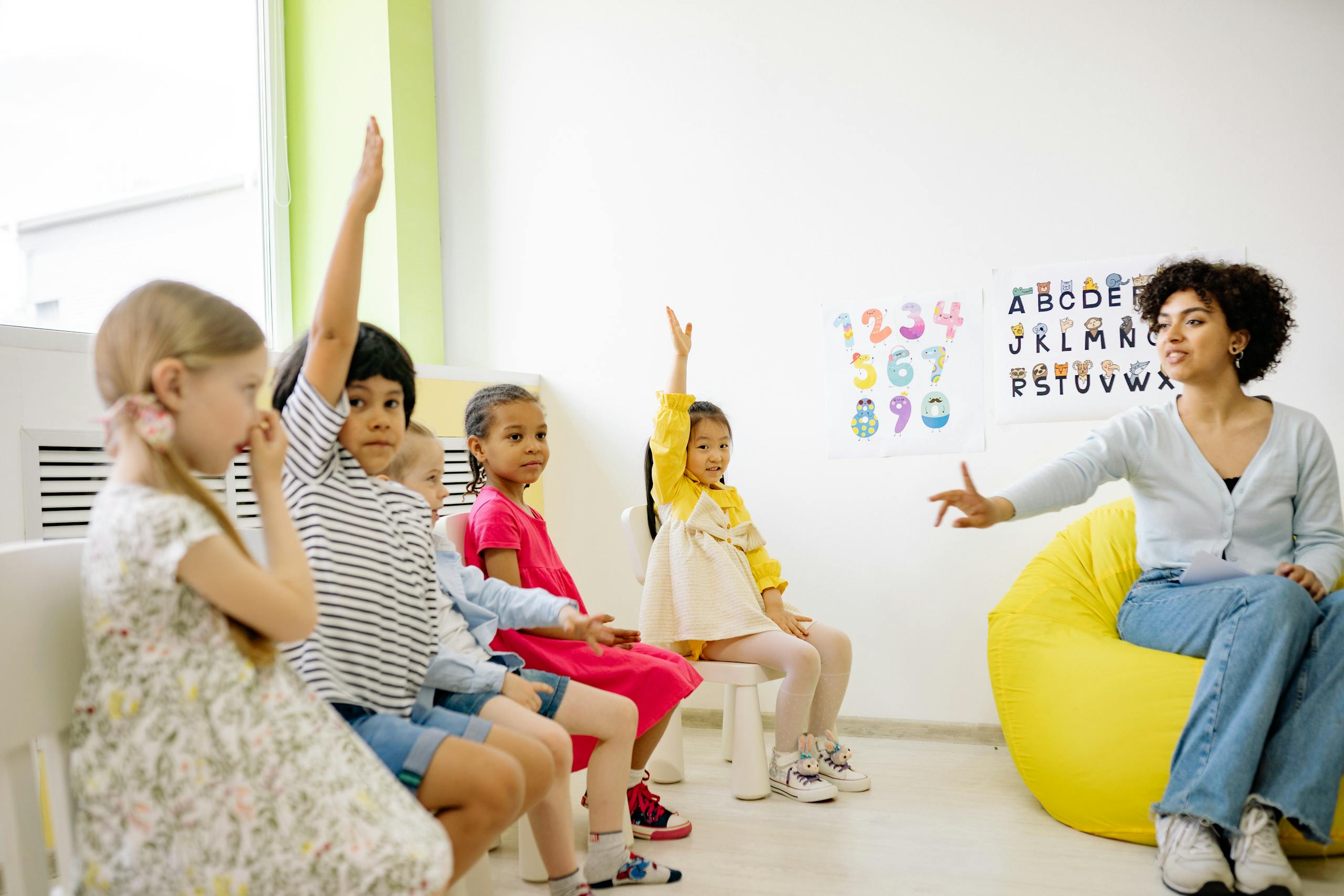 Teacher Giving Lesson and Children Raising Their Hands