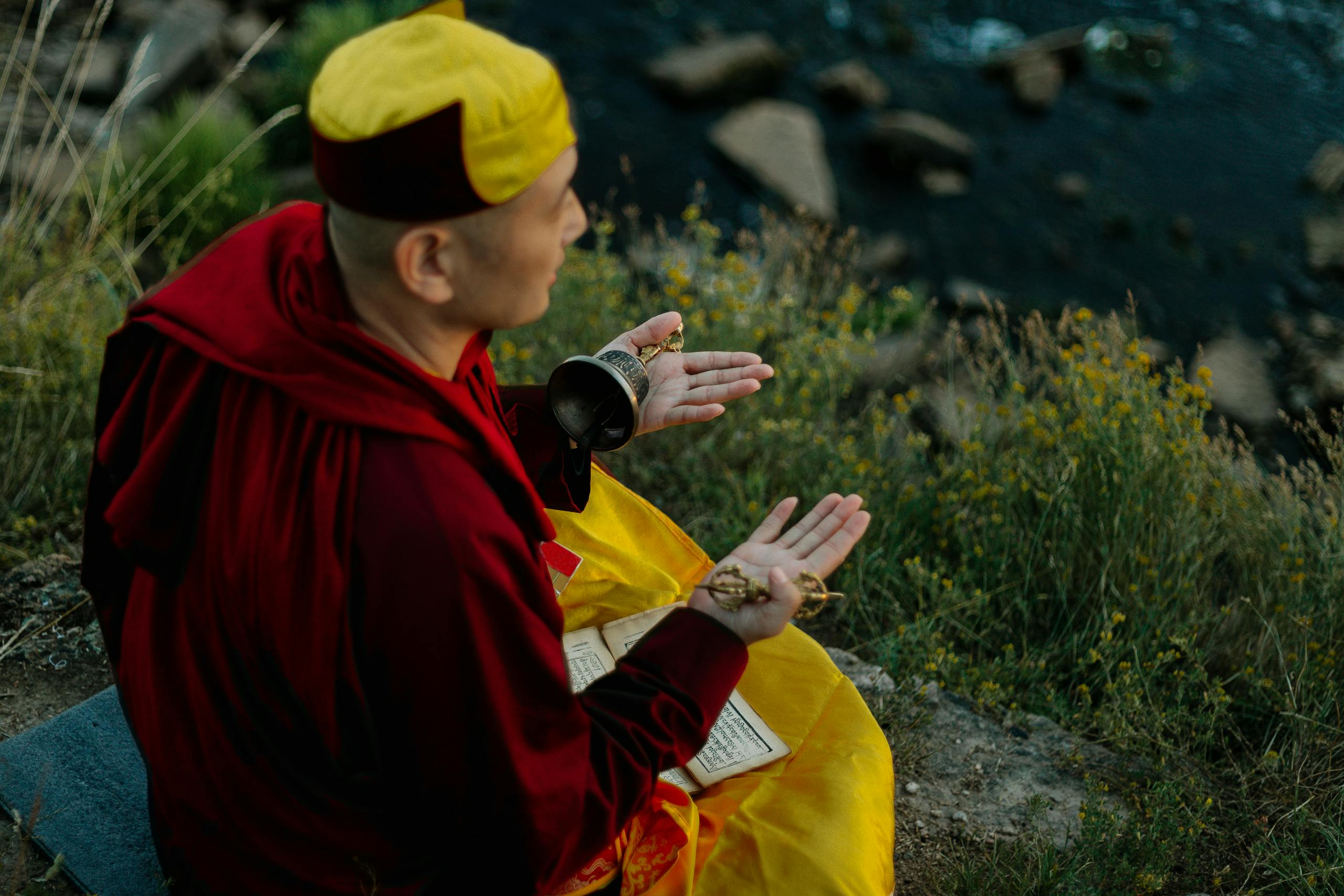 A Man Praying while Holding a Bell
