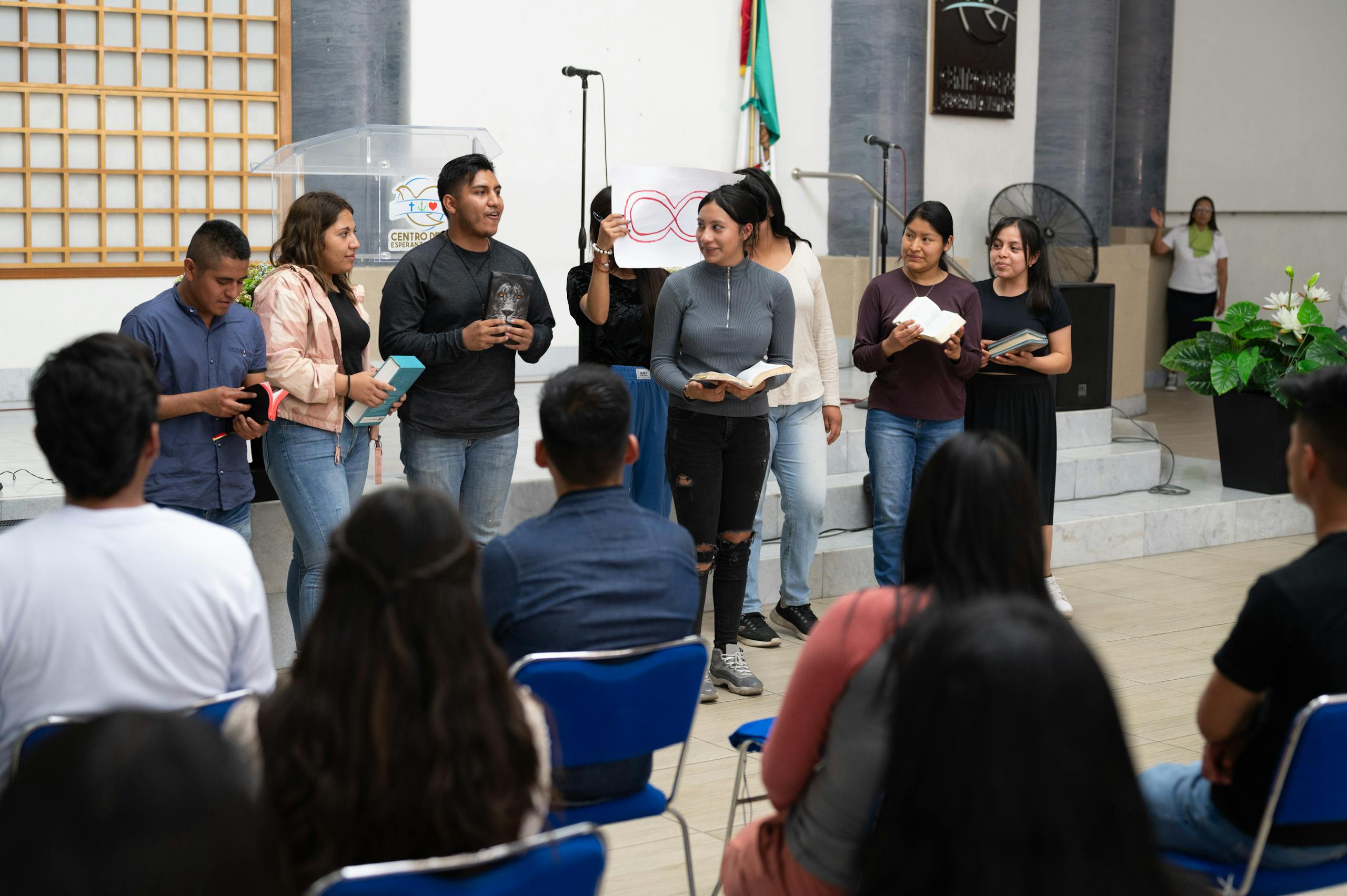 A group of people standing in a room with a speaker